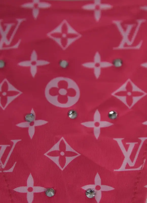 Pink fabric with white floral and logo pattern, embellished with rhinestones.